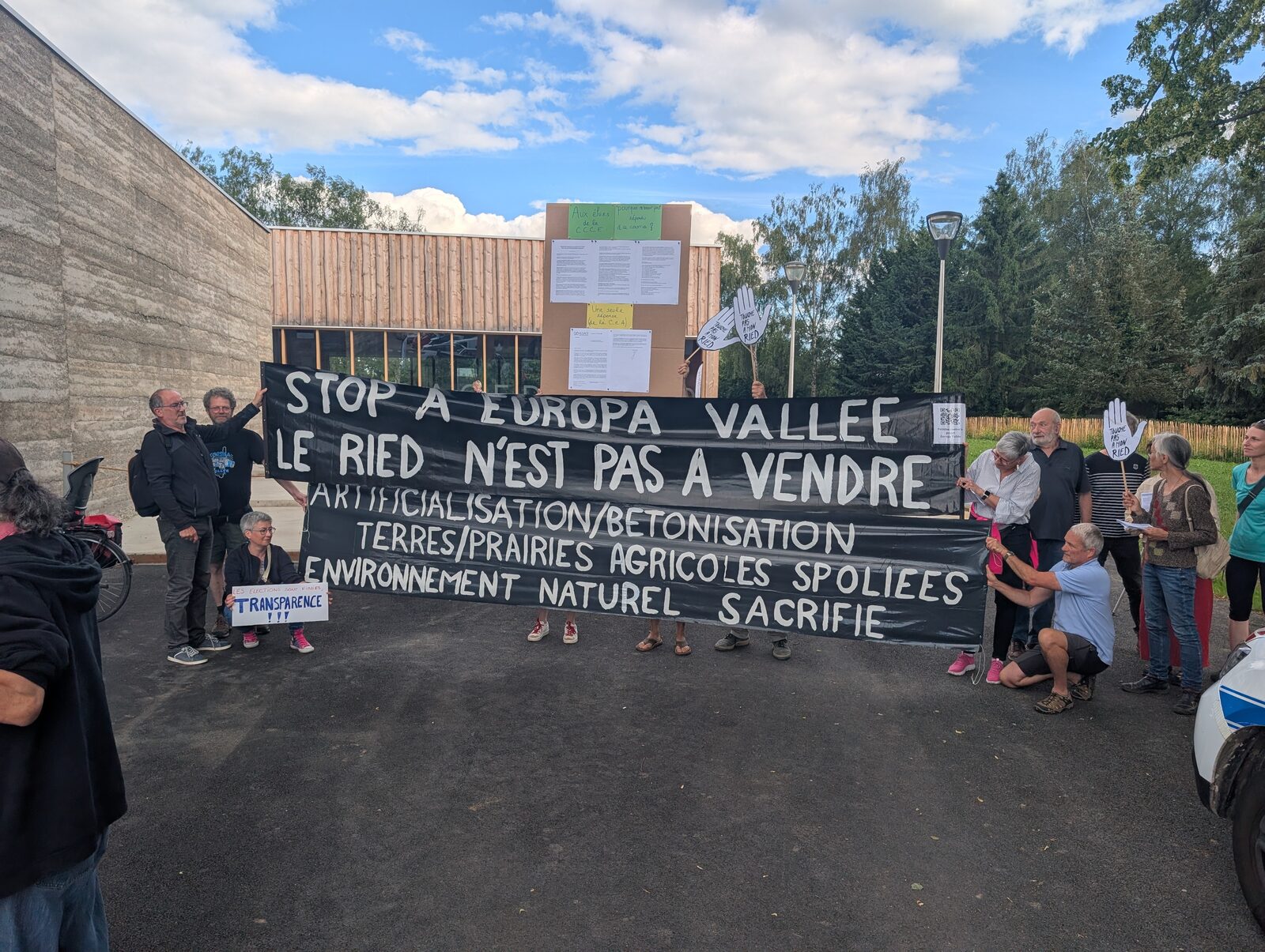 Membres du collectif déployant la grande banderole « Stop à Europa Vallée — Le Ried n'est pas à vendre » à Benfeld
