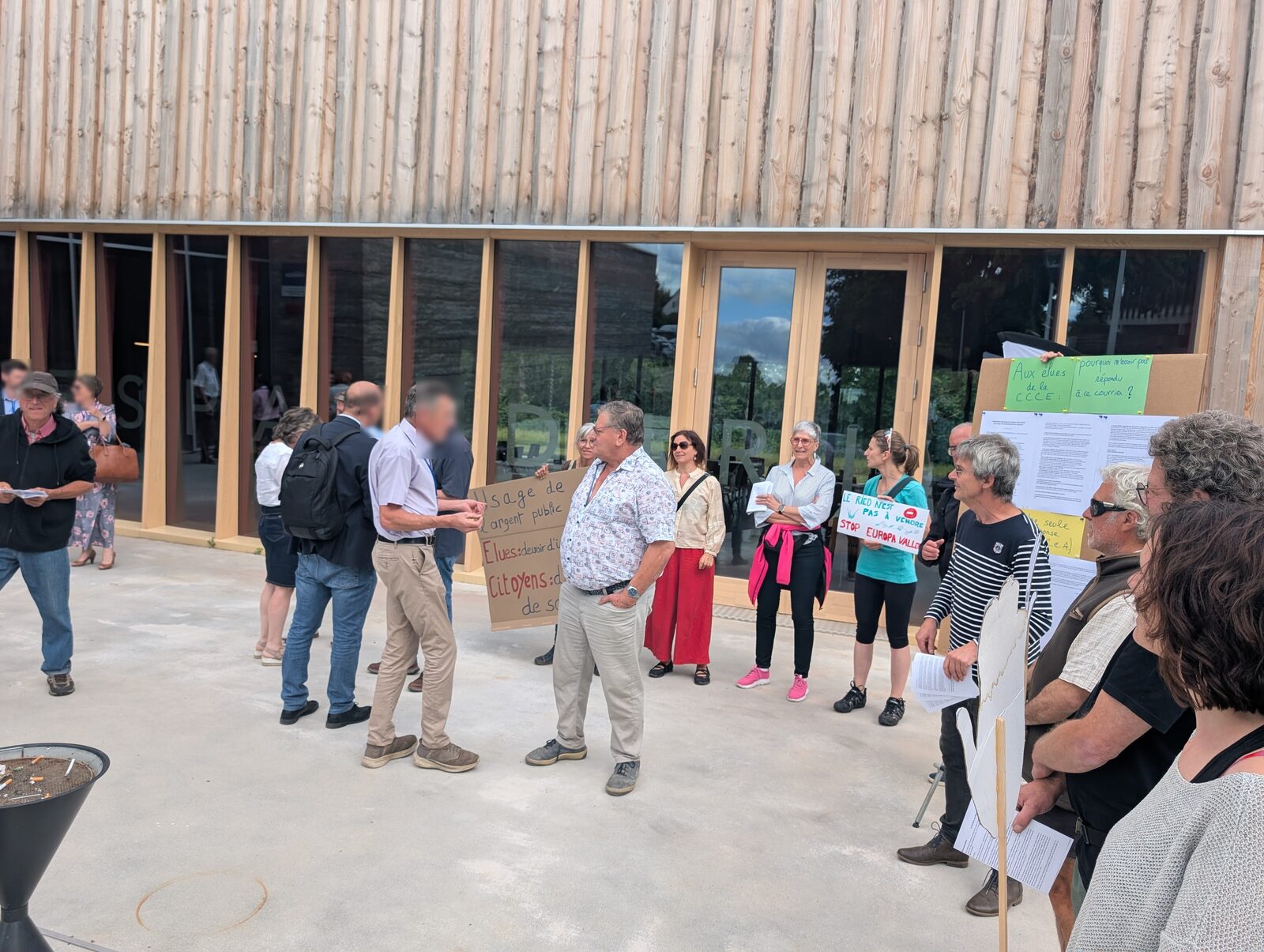 Membres du collectif et pancartes « Usage de l'argent public », « Stop Europa Vallée » devant le bâtiment à Benfeld