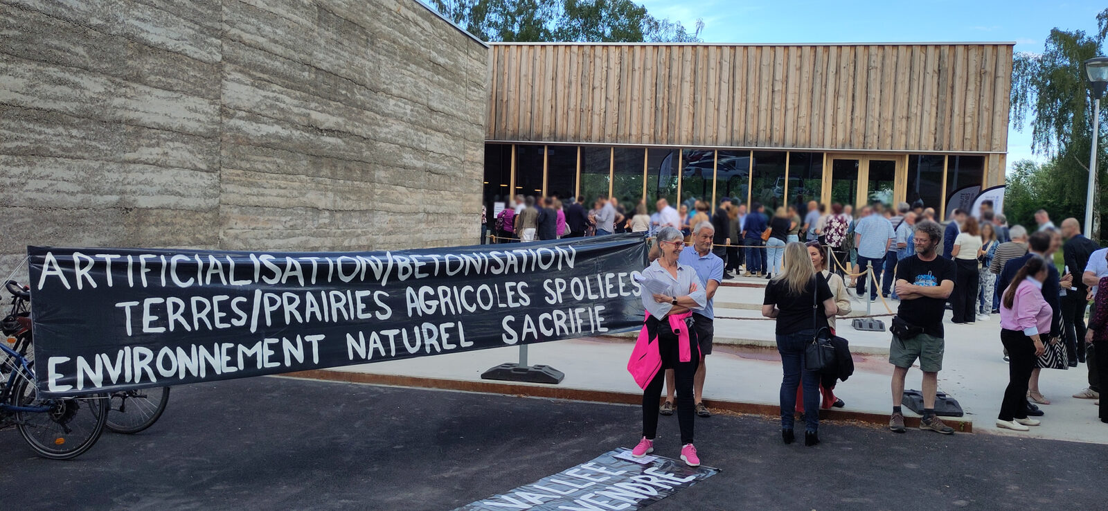 Banderole « Artificialisation, bétonisation » déployée devant l'Espace du Ried, tandis que les élus de la CCCE arrivent au séminaire
